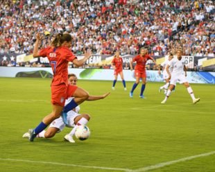 Tobi Heath charges towards the goal, Portugal's player defends the ball.