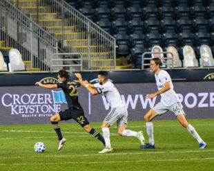 Brenden Aaronson pushes forward even while being chased by 2 DC United Players.