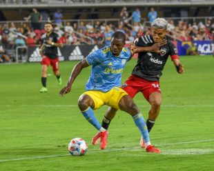 Corey Burke uses his hands and body to shield the ball from Andy Najar just outside D.C. United's box.