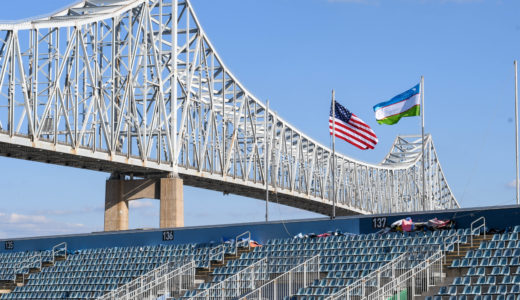 The flags for USA and Uzbekistan fly over the river end.