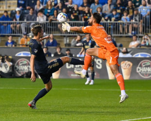 Carlos Coronel gets his hands on the ball before Jack Elliot can get to it.