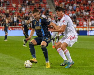 Mikael Uhre works to get the ball around Sean Nealis from the Red Bulls after a long pass from Bedoya.