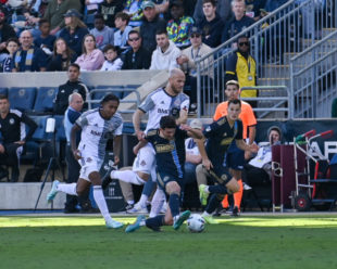 Micheal Bradley takes down Leon Flach. the push from behind earned his a yellow card.