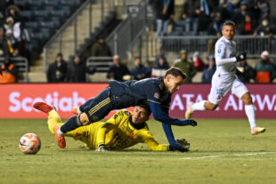 Daniel Gazdag gets tackled by goalie, Mario González as he tried to get a shot off.