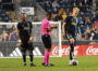 Jon Freemon takes notes on the yellow card issued to José Martínez. Jakob Glesnes laughs at a CF Montreal player after a scuffle.