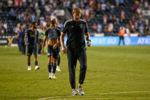 Jim Curtin leaves the field after the game with Kia Wagner in the background.
