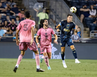 Kai Wagner jumps for a header as Leonardo Campana and Sergio Busquets look on.