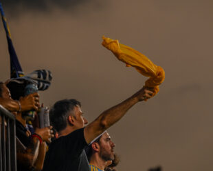 A fan celebrated in the River End against the storm and smoke bombs.