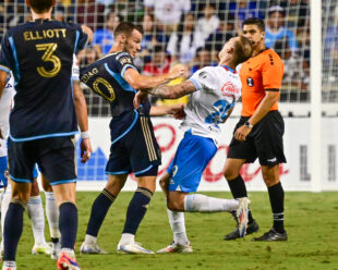 Daniel Gazdag and Carlos Rodolfo Rotondi get physical after exchanging words on the field. Gazdag's jersey is being pulled from behind by a teammate.