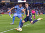 Philadelphia Union's forward 
Mikael Uhre kicks the ball while New York City FC's forward Mounsef Bakrar tries to stop him.