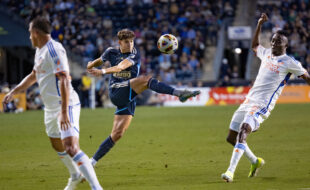 Quinn Sullivan kicks the ball as Obinna Nwobodo attempts to block him.